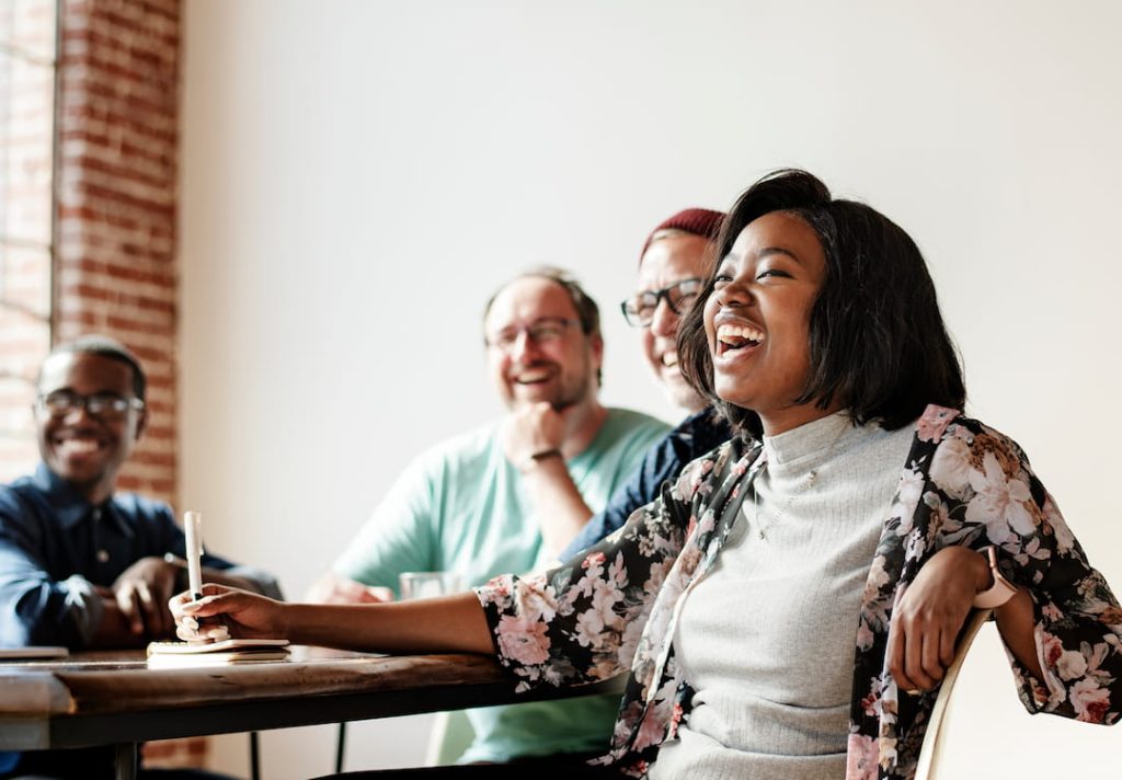 A team of employees smiling and laughing during a casual business meeting