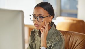 Frustrated female employee looking at her computer in a well lit office room