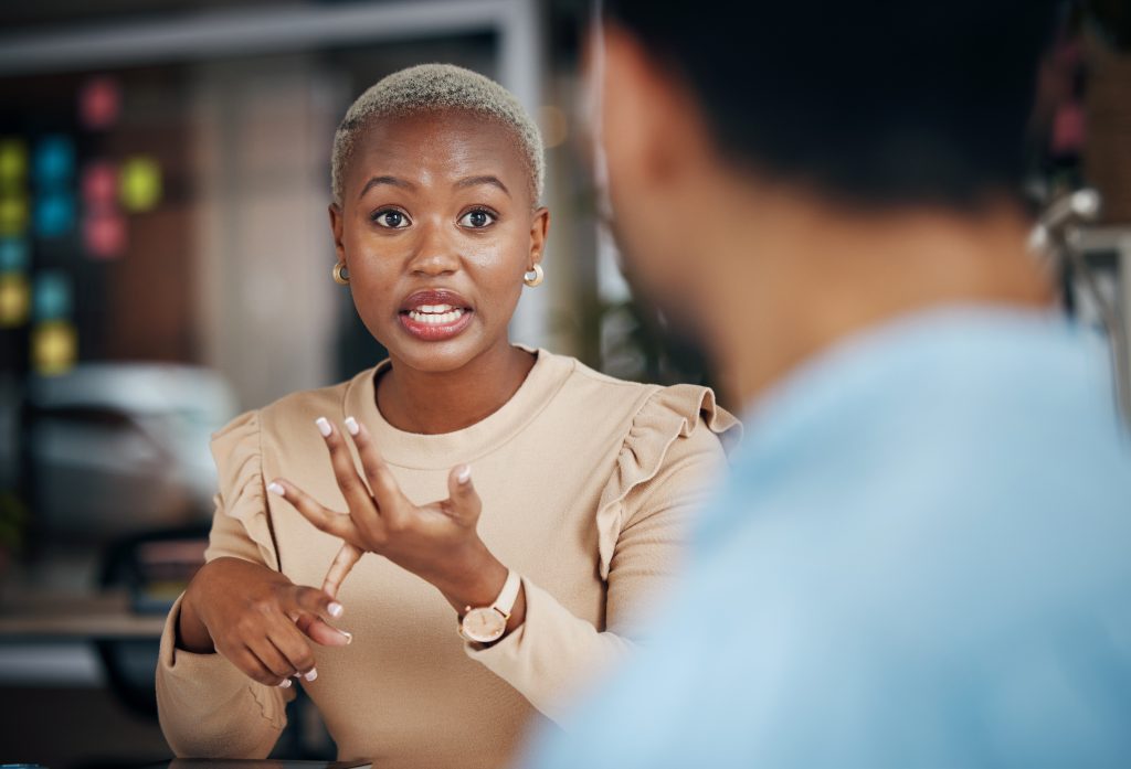 Female HR leader engaged in an in-depth discussion with a coworker in an office building